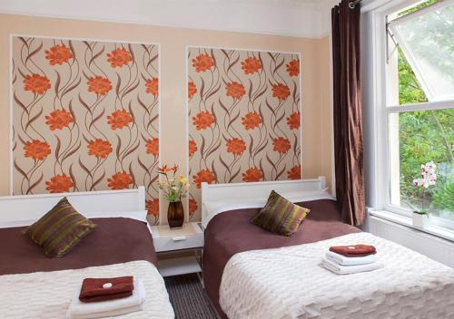 伦敦261酒店的一间卧室设有两张床和窗户。