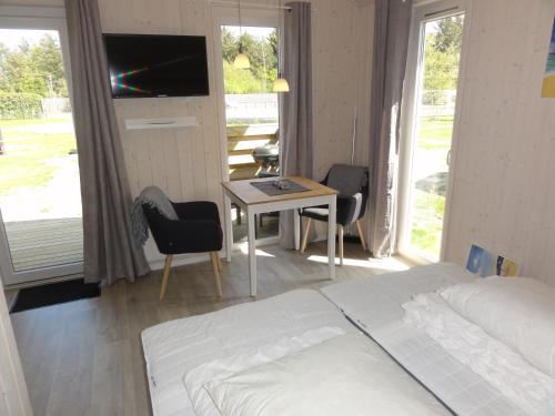 希茨海尔斯Tornby Strand Camping Cottages的一间卧室配有一张床和一张桌子及一台电视