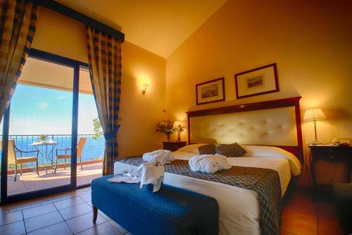 Santa Margherita-Sant'Alessio Siculo希腊人领袖陶尔米纳海岸酒店及Spa的酒店客房设有两张床和一个阳台。