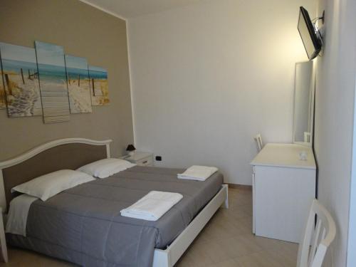 切萨雷奥港Relax Affittacamere的一间卧室配有一张床、一张书桌和一台电视