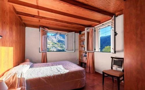 贝加德圣马特奥Villa el Manantial的一间卧室设有一张床和两个窗户。