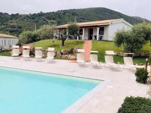 圣特奥多罗Agriturismo La Rocca Manna的一个带椅子和桌子的游泳池以及一座房子