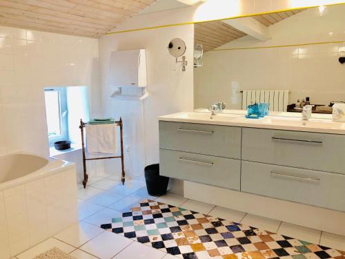 热镇Du Côté de l'Ombrière的白色的浴室设有水槽、浴缸和浴缸。