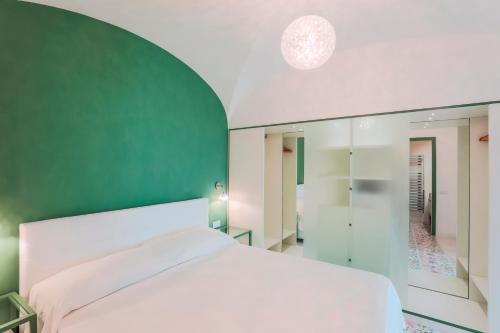 斯卡拉The Lodge的卧室配有白色的床和绿色的墙壁