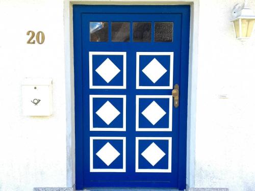 格罗斯齐克Haus Ketzenberg 1 - Lütt Mööv的白色房子的蓝色门