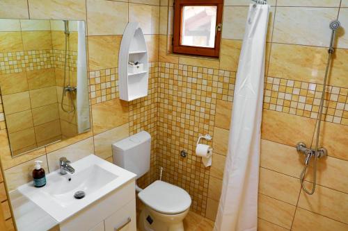 BuzsákJázmin Apartman的浴室配有卫生间、盥洗盆和淋浴。