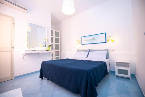 普罗奇达Le Querce的一间卧室配有一张带蓝色毯子的床