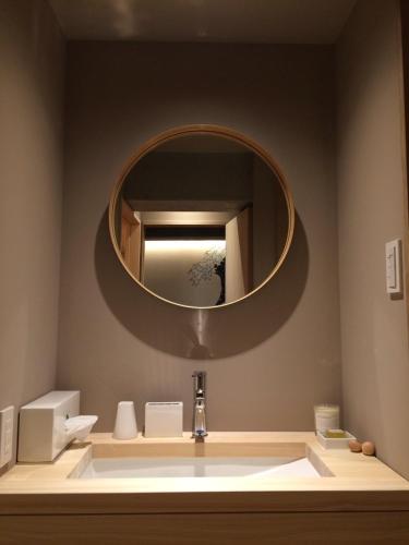 东京WOW-GINZA的一间带水槽和圆镜子的浴室