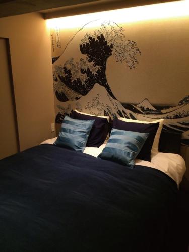 东京WOW-GINZA的一间卧室配有一张壁画床