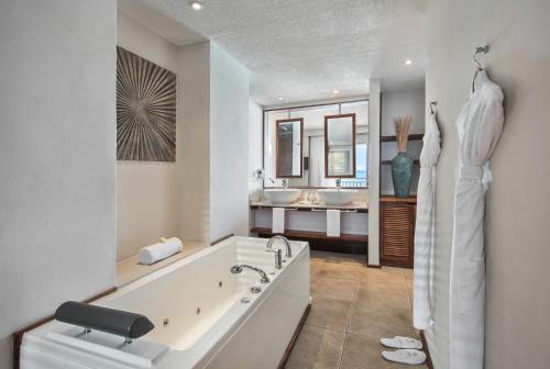 贝尔马尔Solana Beach Mauritius - Adults Only的白色的浴室设有2个盥洗盆和1个浴缸。