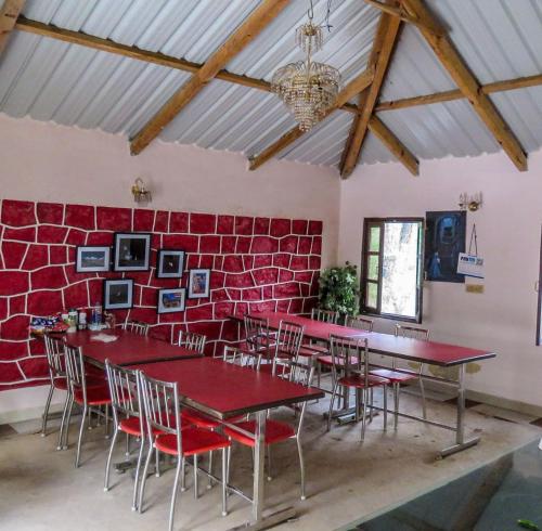 卡绍利Pine Valley Resort的一间设有桌椅和红砖墙的房间