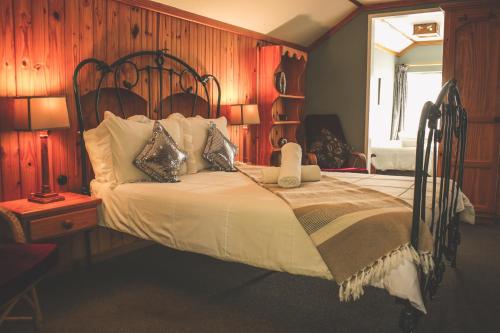 霍维克Biggy Best Boutique Hotel & Self Catering Cottages的一间卧室配有一张木墙床