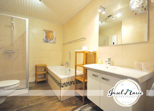 万根沃格INSELMARIE Wangerooge的带浴缸、盥洗盆和卫生间的浴室
