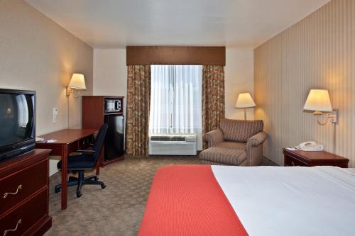 拉斯维加斯亨德森智选假日酒店的酒店客房配有一张床、一张书桌和一台电视。