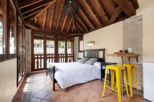 格拉纳达格拉纳达城市套房酒店的一间卧室配有一张床、一张桌子和黄色凳子