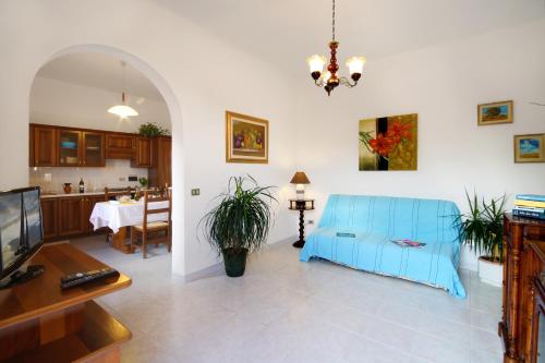 因佩里亚Appartamenti Villa Chiara的客厅配有蓝色的沙发和桌子