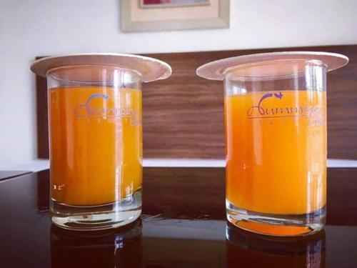 卜山Hummingbird Resort的桌子上放两杯橙汁