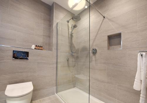 波特拉什Golflinks Hotel的一间带卫生间和玻璃淋浴间的浴室