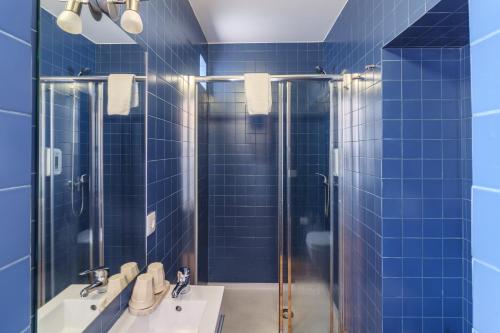 波尔图林多谷旅馆的蓝色瓷砖浴室设有2个水槽和淋浴