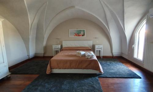 乌真托Palazzo Novecento的一间卧室配有一张床和两张桌子