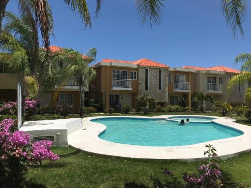 蓬塔卡纳Punta Cana Apartment and scooter for free的房屋前的游泳池