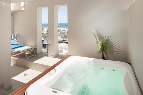 里米尼国宾大酒店的带浴缸的浴室,享有海景。