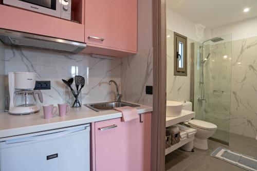 普拉塔尼亚斯Sonio Beach - Que Bella Collection的粉红色的厨房设有水槽和卫生间