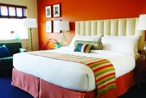 旧金山Hotel Del Sol的橙色墙壁的房间里一张大白色的床