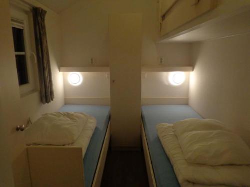 ReutumLodge 6 personen camping de Molenhof的小房间设有两张床和两个灯