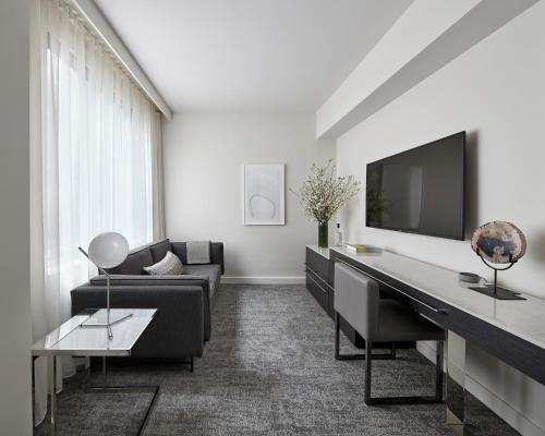 纽约Smyth Tribeca的带沙发、书桌和电视的客厅