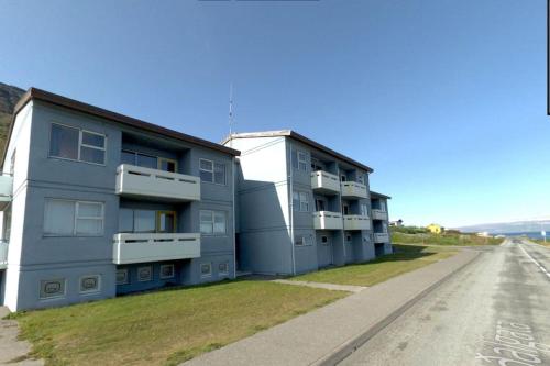 SúðavíkSúðavík apartment的蓝色建筑,在路边设有阳台