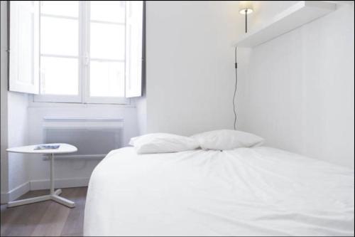 波尔多格艾伯吉斯公寓的白色卧室配有床和桌子