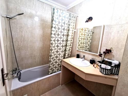 波尔蒂芒Apartamento Jeni Residencia Flamingo的一间带水槽、浴缸和淋浴的浴室