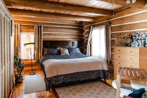 Grenville-sur-la-RougeLe petit Montebello的一间卧室设有一张床和木墙