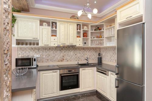 兹蒂尔Mountain Resort Residences的厨房配有白色橱柜和不锈钢冰箱