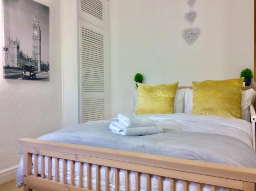 迪德科特Station House的一间卧室配有一张带黄色枕头的床