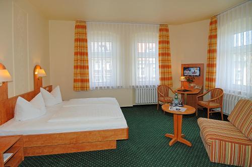 勒鲍Hotel Stadt Löbau的酒店客房,配有床和沙发