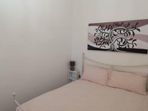 夏卡Sciacca sea view holidays centro storico的卧室配有一张床,墙上挂有绘画作品
