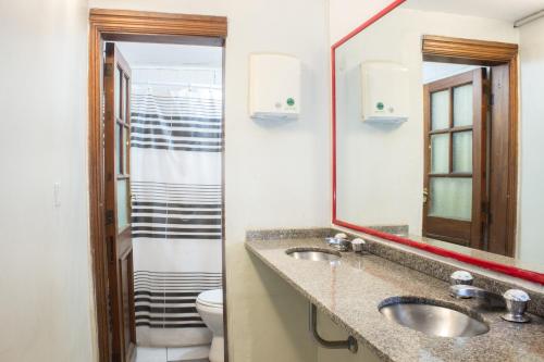 布宜诺斯艾利斯Play Hostel Arcos的浴室设有2个水槽、卫生间和镜子。