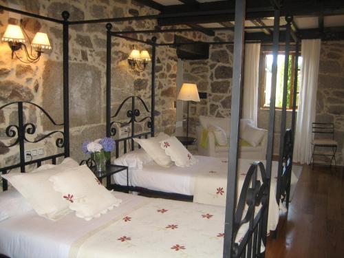 阿波夫拉德特里韦斯帕左弗雷利亚酒店的一间卧室设有两张床和石墙