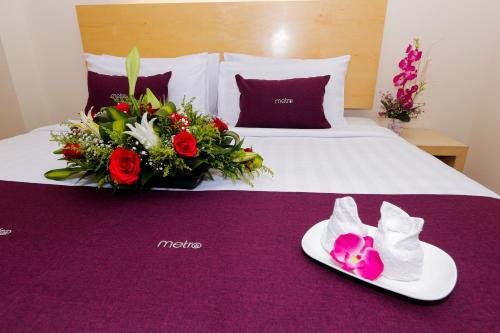吉隆坡吉隆坡中心都会酒店的一间酒店客房,床上挂着鞋子和鲜花