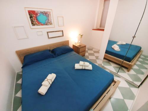 圣凯撒利亚温泉Casa con terrazza vista 180° sulla costa orientale的一间卧室配有蓝色的床和拖鞋