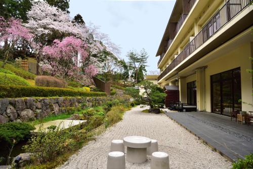 龟冈京汤之花翠泉日式旅馆的一条行人通道,毗邻一座粉红色花卉的建筑