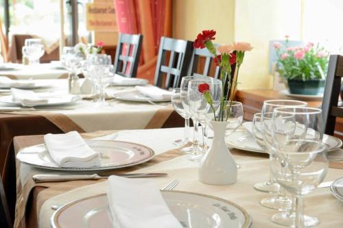蓬托尔松Logis Hôtel et Restaurant La Tour Brette的桌子上放着玻璃杯和盘子,花朵