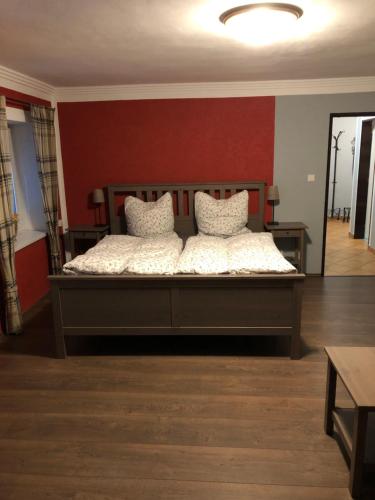 PetrovicePenzion RETRO的一张大床,位于一个红色墙壁的房间
