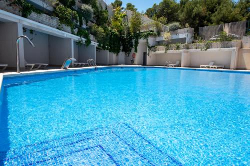 阿利坎特Alicante Hills Luxury Beach Apartment的大楼里的一个大型蓝色游泳池
