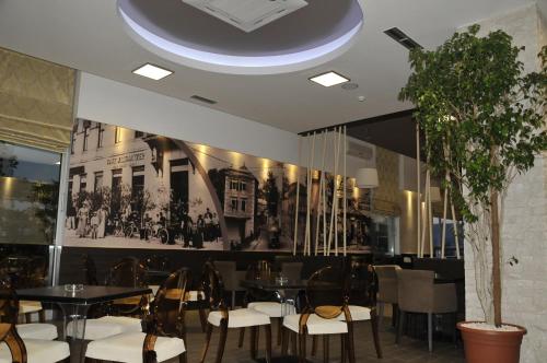 莫斯塔尔Hotel Malta的一间带桌椅的用餐室和一面墙