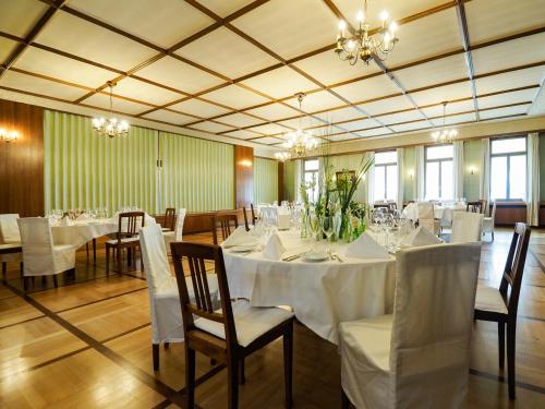 Madiswil巴雷兰德加斯特霍夫酒店的一间配备有白色桌椅和吊灯的餐厅