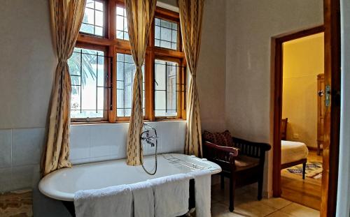 开普敦Redbourne Hilldrop Guesthouse B&B的带浴缸和窗户的浴室