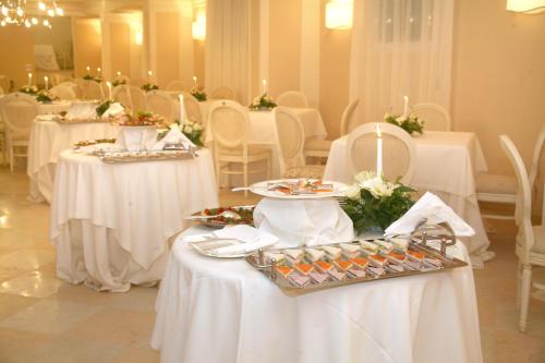 维耶斯泰维埃斯特皇宫酒店的用餐室配有白色的桌子和白色的椅子